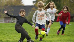 Crianças jogando futebol com um NIE Sessão